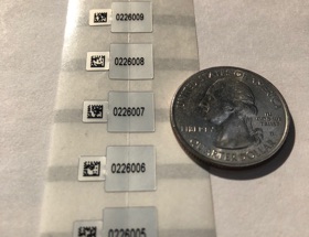 Micro PCB Labels in scale next to a quarter